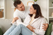© Pixel-Shot - Happy young couple hugging on sofa at home