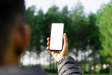 Mockup image of a man using smartphone with blank white screen at outdoor
