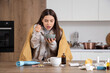 © Pixel-Shot - Sick young woman eating chicken soup in kitchen