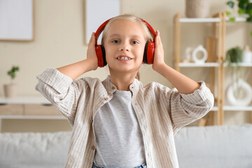 Wall Mural - Little girl with headphones  listening to music at home