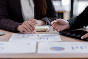 Wall Mural - Business financing accounting banking concept. Two asian Business doing finances and calculate on desk about cost at workplace. Business working on desk with using calculator, finance accounting.
