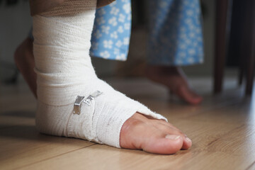  An injured foot wrapped in a bandage is gently resting on the floor, awaiting care and healing
