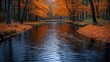 © logyartstudios - Calm autumn river flowing through vibrant orange forest.