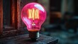 © larrym - Illuminated Pink Glass Edison Bulb On Wood
