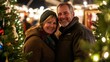 © jureephorn - A happy couple posing with their selected Christmas tree at a holiday fair, surrounded by sparkling lights and decorations, exuding joy and holiday spirit