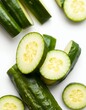 © kengkreingkrai - there are cucumbers cut into pieces on a white surface.