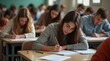 © Alex Pios - busy exam room filled with students taking their final exams, with papers, pencils, and focused expressions