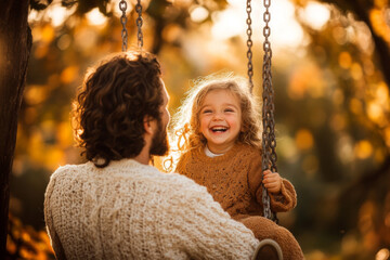 Wall Mural - A joyful moment captured as man and girl enjoy swinging together in beautiful autumn setting, surrounded by warm golden leaves. Their laughter fills air, creating heartwarming scene