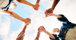 © Siphosethu F/peopleimages.com - Friends, people and holding hands outdoor for teamwork, synergy or solidarity by sky. Group, support and community of students in circle for cooperation, association or collaboration at college below