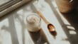 © cynz - A closeup of a jar of Himalayan salt next to a wooden spoon, sitting on a clean counter, representing mindfulness and purity
