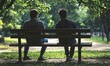 © jambulart - Two people sit silently on park bench.