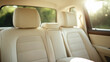 © Bonsales - Empty cream leather seats wait in the back of a modern suv, showcasing a clean interior and safety features