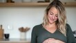 © MOMI - A pregnant woman smiles gently, cradling her belly. Soft lighting and neutral tones create a serene atmosphere.