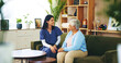 © peopleimages.com - Smile, conversation and old woman on sofa with caregiver for senior care, support and trust in lounge at home. Homecare, elderly person and nurse on couch with healthcare advice, bonding and comfort
