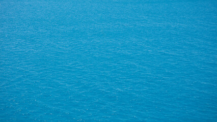 Poster - Sea water is blue and calm as background. There are no ripples or waves. The water is clear and still