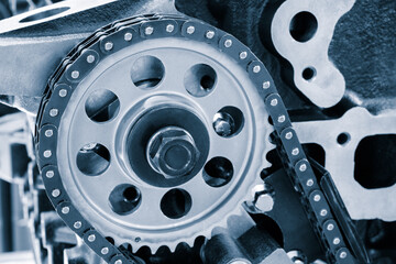 Aufkleber - A chain is attached to the engine. The chain is silver and has a lot of holes. chain is attached to a gear
