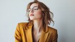 © WITTAYA  ANGMUJCHA - Stylish and confident woman wearing a gold blazer, set against a pristine white backdrop.