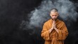 © AndiAzis - A monk in meditation with hands in prayer pose.