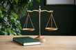 © barmaleeva - Old fashioned balance scale beside a stack of law books