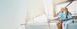 © peopleimages.com - Ocean, banner and couple on boat for holiday, vacation and travel with love or adventure in Greece. Mockup space, romantic date and people hug on yacht at beach to relax for sailing trip and view