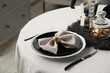 © New Africa - Stylish table setting with black dishware in dining room