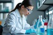 © NeedMoreMars - Concentrated female scientist in white lab coat and goggles conducting precise experiment with blue liquid in modern laboratory setting.