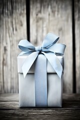 Wall Mural - A beautifully wrapped gift box with a light blue ribbon on a rustic wooden background.