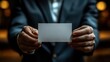 © practice  - Close-up of a professional businessman’s hand presenting a blank white business card for networking and corporate meetings