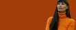 © Sascha - Thoughtful woman in orange turtleneck sweater against solid background with copy space