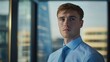 © Alex - Confident young businessman in smart attire gazes thoughtfully out the window. Modern office background adds depth to the scene.
