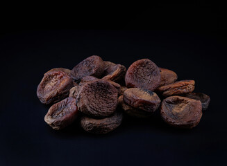 Wall Mural - Dark mountain dried apricots on a black background