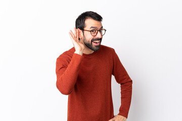 Wall Mural - Caucasian handsome man with beard over isolated white background listening to something by putting hand on the ear