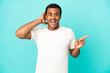 © luismolinero - African American handsome man on isolated blue background surprised and pointing finger to the side