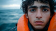 © Kondor83 - Male illegal migrant, refugee wearing life vest in stormy sea