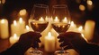 © Tokyo - A photo of two hands toasting with wine glasses, with the focus on their intertwined fingers and the clinking glasses in front of an out-of-focus background of glowing candles. The lighting is soft an