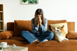 © Home-stock - Young woman suffering from pet allergy, blowing nose with napkin while sitting on sofa with her Welsh Corgi dog at home in living room interior