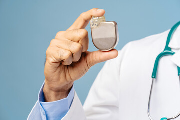 Portrait of professional doctor, cardiologist holding pacemaker selective focus on hands, closeup