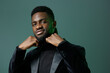 © SHOTPRIME STUDIO - Confident african man in stylish black attire posing against vibrant green background