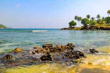 Poster - Picturesque tropical beach with boulders and tropical palm trees.