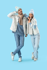 Wall Mural - Loving couple in winter clothes on blue background