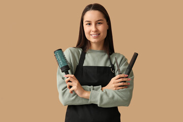 Wall Mural - Female hairdresser with scissors, brush and comb on brown background