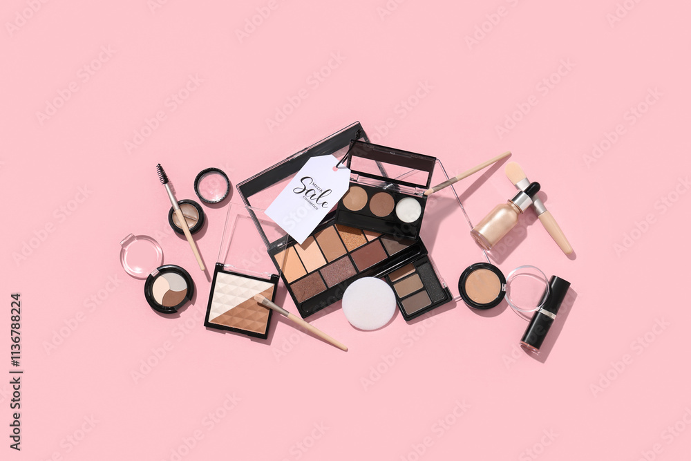 Composition with decorative cosmetics, makeup brushes and sale tag on pink background