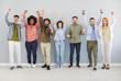 © Studio Romantic - Happy joy of confident multiracial group of international company workers standing in line near wall, successful young team members portrait diverse business people looking at camera, success teamwork