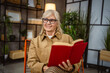© Miljan Živković - senior beautiful woman enjoy in the living room while read a book