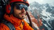 © Юлия Гриб - Helicopter Pilot Wearing Orange Jacket and Sunglasses Enjoys Stunning Mountain Views During Scenic Flight in Winter