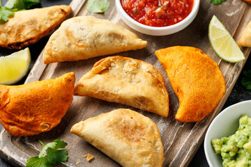 Freshly served traditional empanadas on wooden board. Mexican food