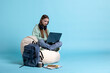© DC Studio - Woman typing on laptop, preparing for school exam, isolated over blue studio background. Diligent student using notebook to prepare for university classes, studio backdrop