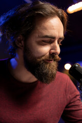 Fototapete - Songwriter composing new music and singing on microphone, playing piano keyboard and recording song for mixing and mastering session. Artist using audio equipment in home studio. Close up.