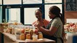 © DC Studio - Vendor giving fresh homemade sauces to customer, recommending ethically sourced additives free goods. African american client examining organic natural products at local store.