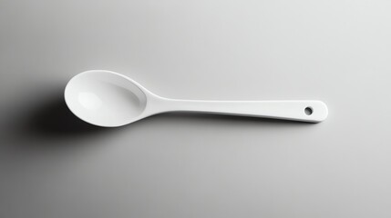 A white ceramic spoon on a white surface.